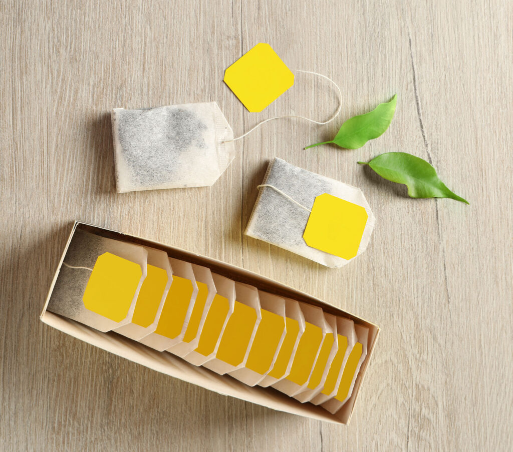 Box with paper tea bags and leaves